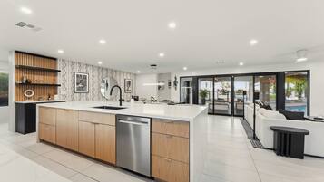 A modern kitchen with a central island, wooden cabinetry, and a built-in dishwasher.