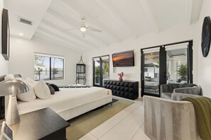 A modern bedroom with a bed, bedside table, and a large window.