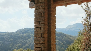 A stone structure with a wooden roof and a balcony railing. - Hotel Santa Llucia Rupit (Rupit I Pruit)