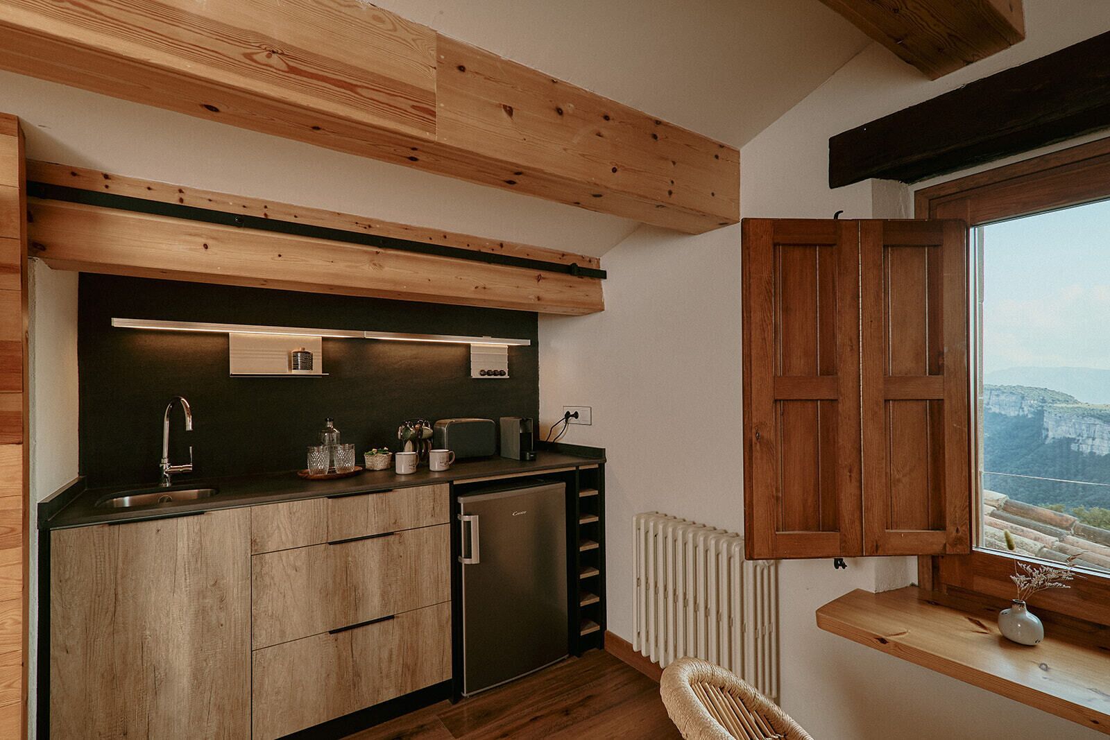 Une cuisine moderne avec des poutres en bois, un évier encastré et une fenêtre offrant une belle vue.
