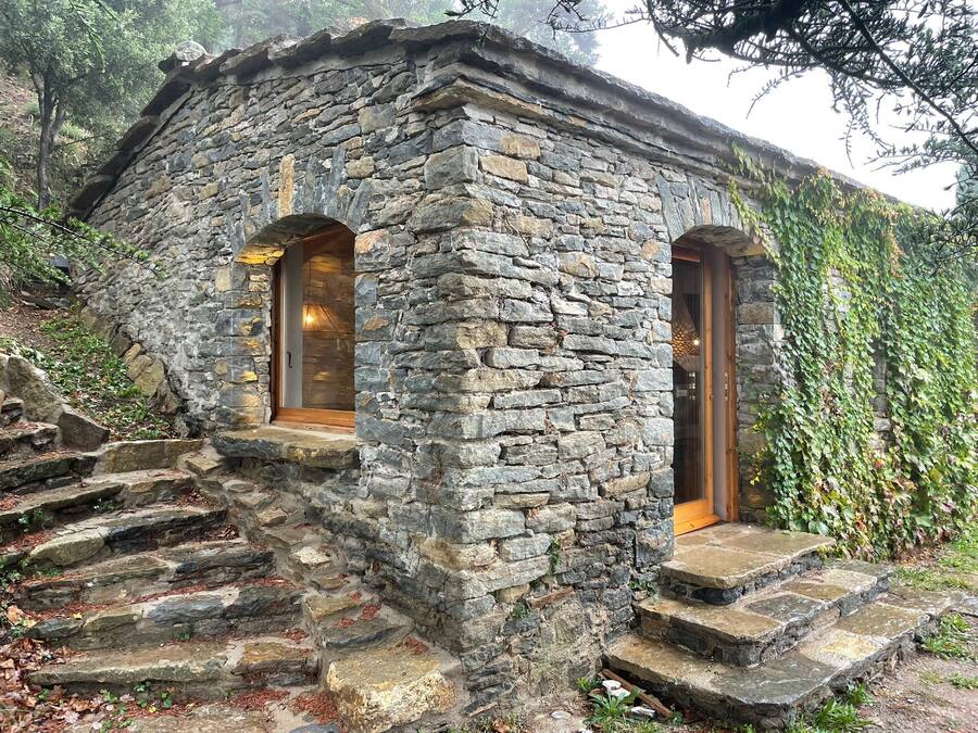 Un edificio in pietra con due portali ad arco e una rampa di gradini in pietra che conduce all'ingresso.