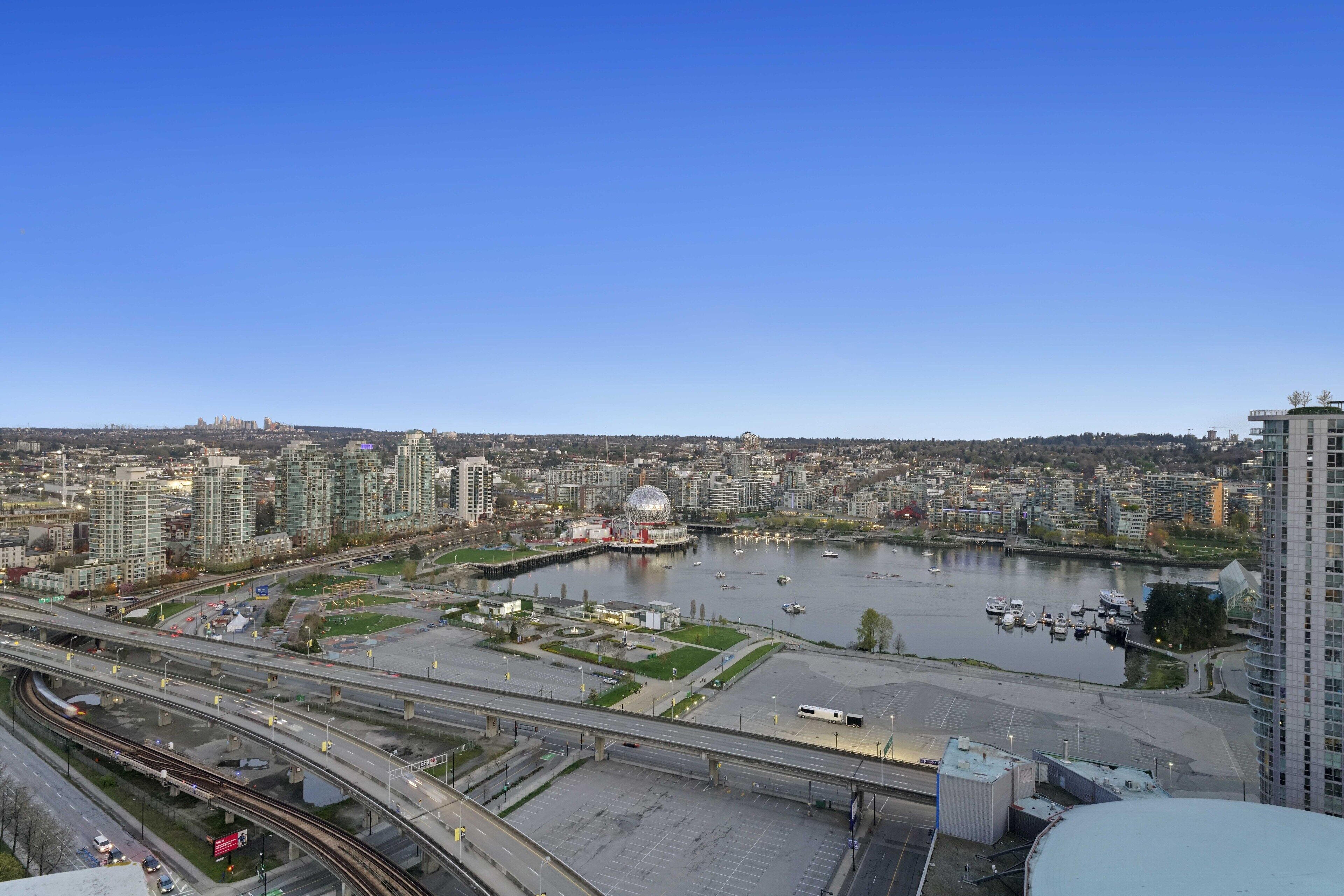 A cityscape with a river, bridges, and high-rise buildings.