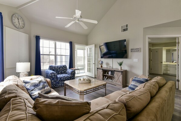 A living room with a ceiling fan, a television, a sofa, a coffee table, and a window with curtains. - AMAZING  3 Bedroom - 3 Bath Condo / Gorgeous Views / Heart of Branson / Spacious (Branson)