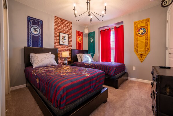 Un dormitorio con dos camas, una pared de ladrillo y varios letreros temáticos.