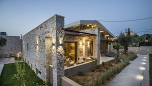 Una casa moderna con paredes de piedra, techo plano y un interior bien iluminado.