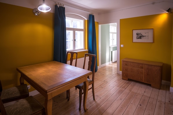 A dining area with a wooden table and chairs, a bench, and a cabinet.
