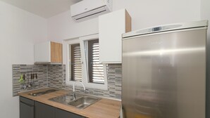 A modern kitchen with a stainless steel refrigerator, wooden countertop, and a tiled backsplash. - Apartment with sea view 1 (Pirovac)
