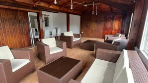 A spacious indoor area with wicker furniture and wooden flooring. - El Montserrat - Hotel Boutique (Santiago de los Caballeros)