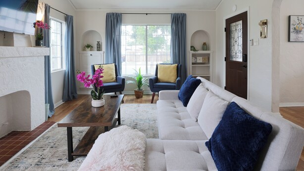 A living room with a fireplace, a sofa, a coffee table, and a television.