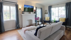A living room with a sofa, a coffee table, a fireplace, and a television.