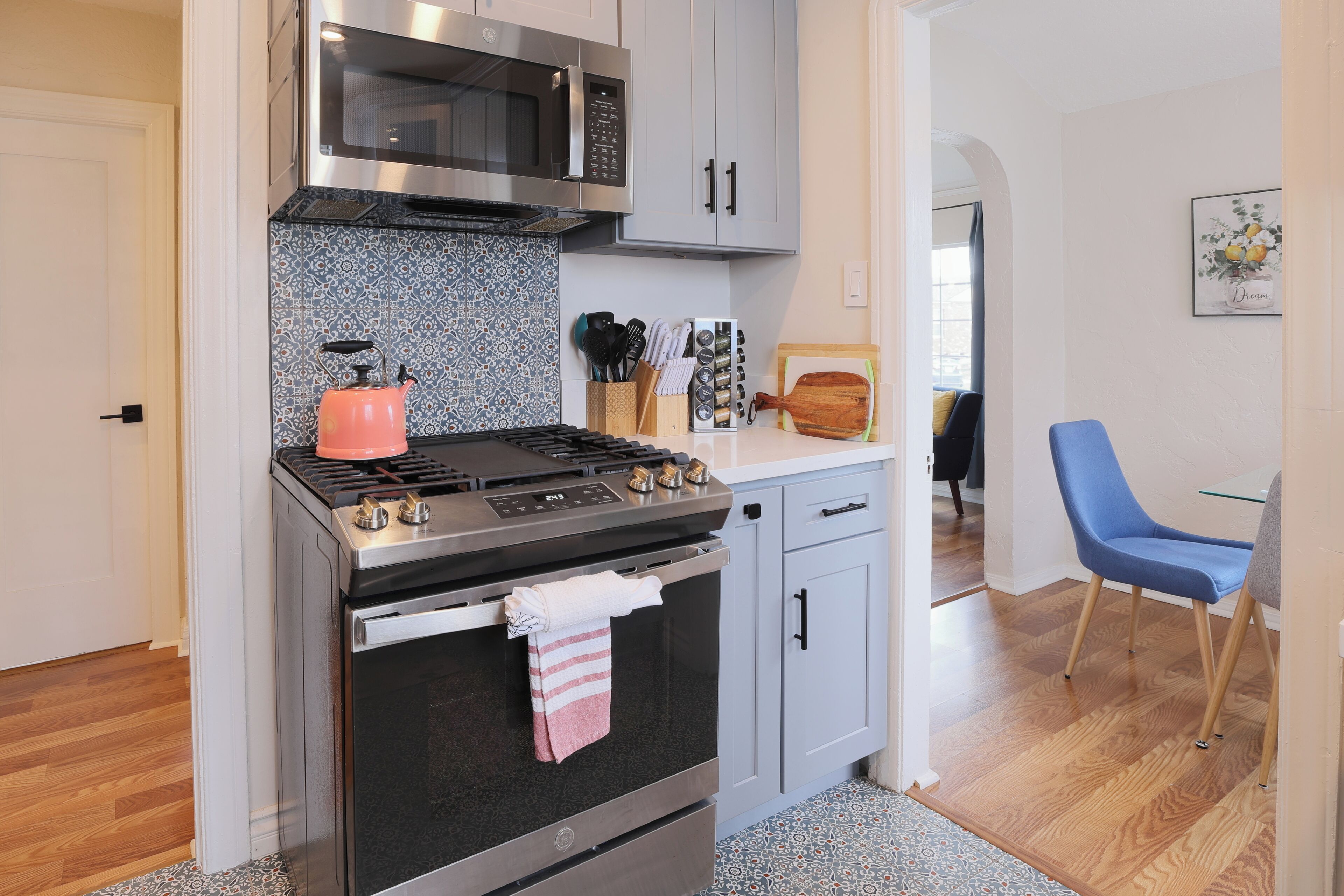 A kitchen with a stove, oven, microwave, and cabinets.