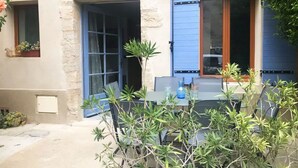 A building with a stone facade, a blue door, and a table with potted plants. - Charming house in the heart of Provence (Cucuron)