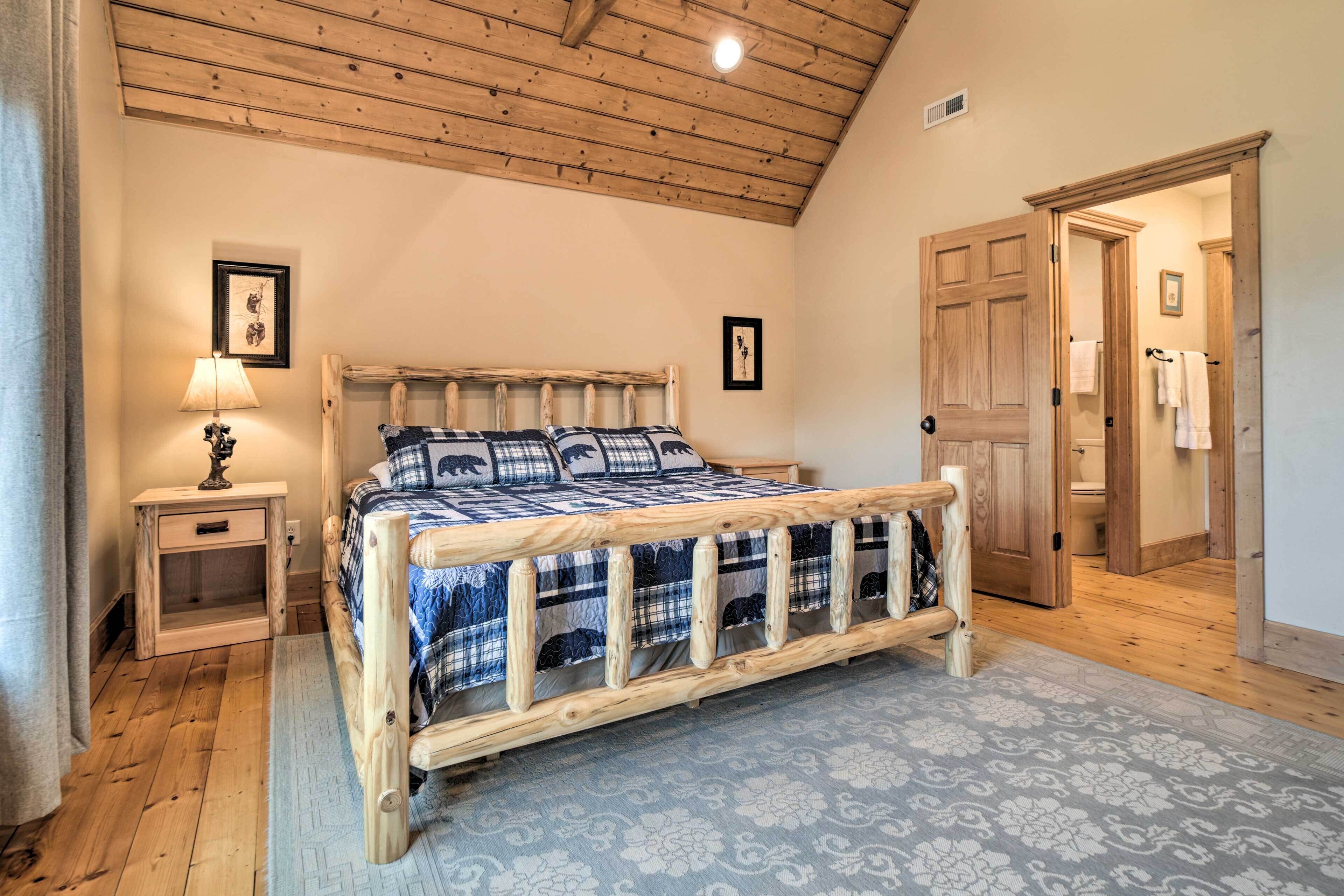 Une chambre à coucher avec un lit en bois, une table de chevet, une lampe et une porte donnant sur une autre pièce.