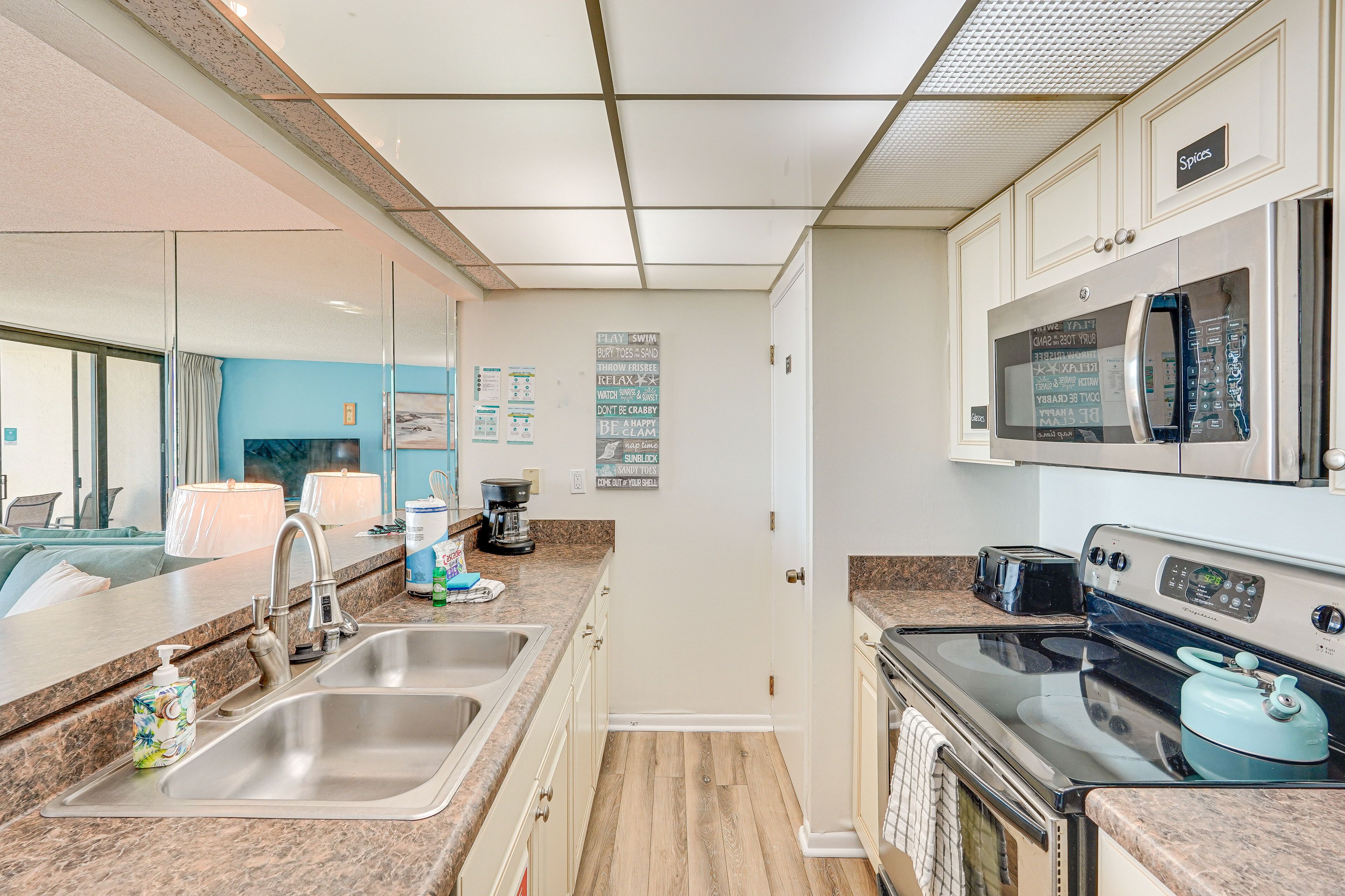 A modern kitchen with stainless steel appliances, a double sink, and a microwave.