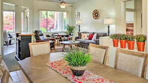 Un salon spacieux comprenant une table à manger, des chaises, un canapé et un ventilateur de plafond.