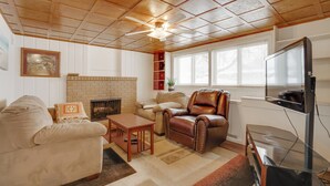 A living room with a fireplace, leather armchair, and a flat-screen TV. - Pet-Friendly Minneapolis Apt Near Shops & Dining! (Minneapolis)
