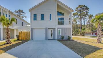 A two-story house with a front garage, a covered porch, and a well-maintained lawn.