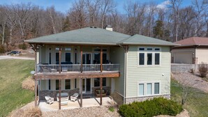 A two-story house with a balcony, a garage, and a driveway.