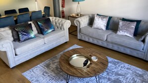 Una sala de estar con dos sofás, una mesa de centro y una lámpara.