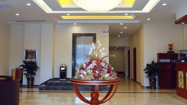 A lobby with a central round table, a chandelier, and a reception desk. - Greentree Inn Xuzhou Kuangda Huaita East Gate Express Hotel (Xuzhou)