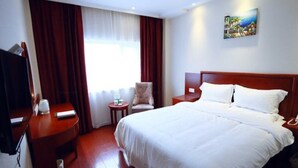 A hotel room with a large bed, a desk, a chair, and a television. - Greentree Inn Xuzhou Kuangda Huaita East Gate Express Hotel (Xuzhou)