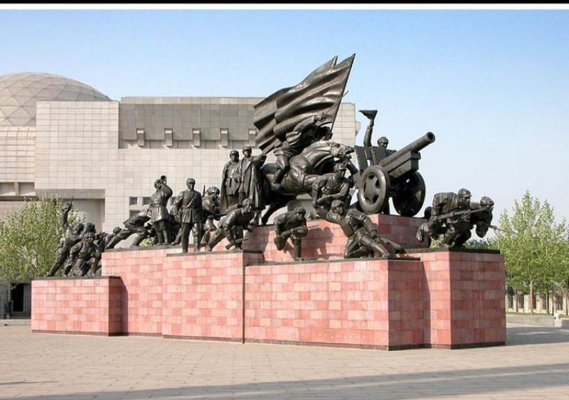 A large outdoor statue of soldiers and military equipment.