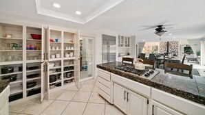 Una cocina moderna con armarios blancos, encimera de granito y horno empotrado.