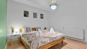 Ein modernes Schlafzimmer mit einem hölzernen Bett, weißen Wänden und einer grünen Akzentwand.