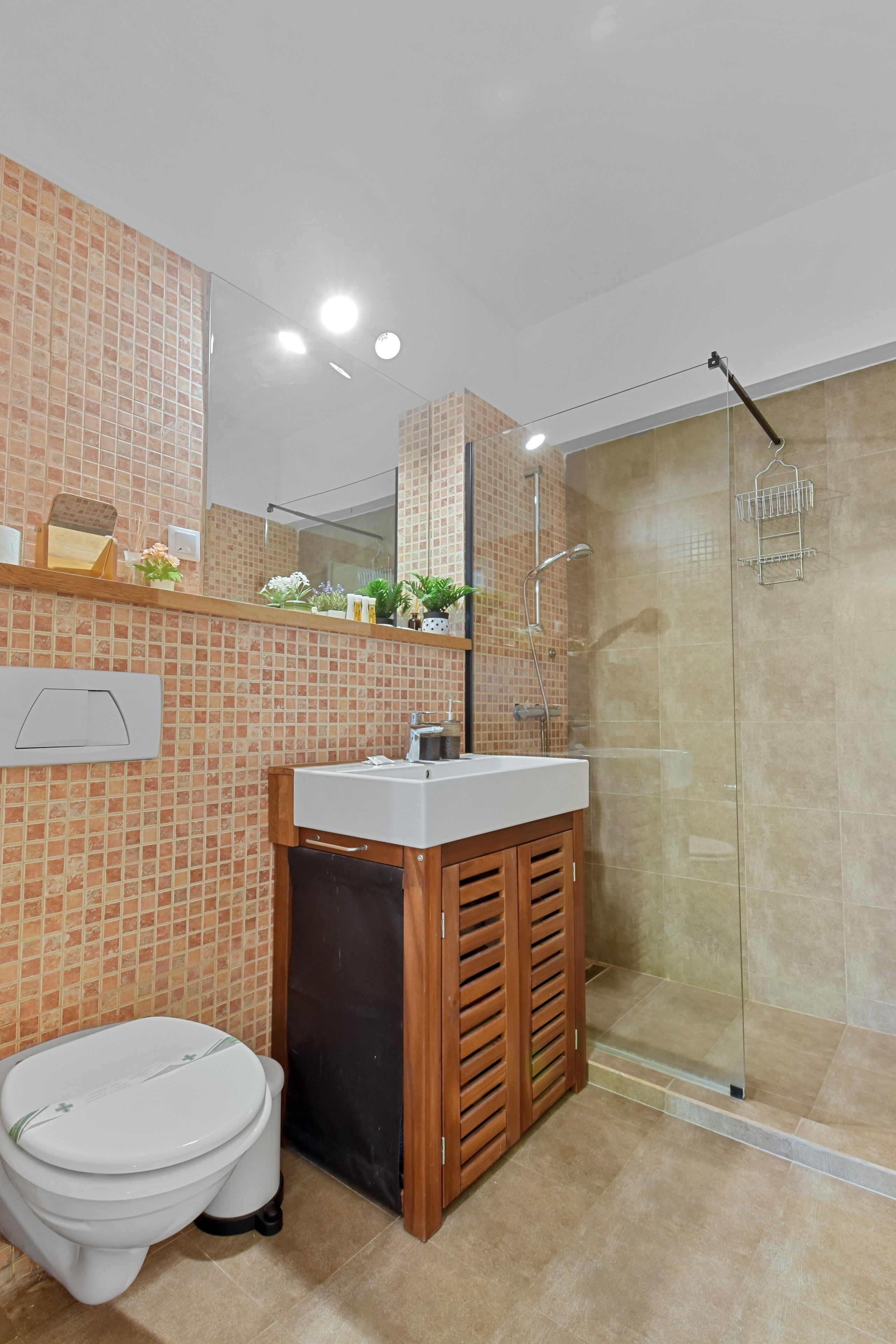 A bathroom with a toilet, sink, and shower.