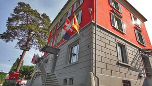 Un edificio de varios pisos con fachada roja y numerosas ventanas.