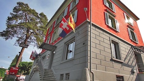 A red building with multiple flags, including a Swiss flag, and a sign that reads 'Hotel'. - Gasthaus zur Waldegg, BW Signature Collection (Horw)