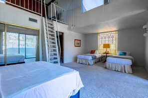A bedroom with two beds, a staircase, a window with stained glass, and a door leading outside. - Oceanfront-2730 sqft w/SPA, HugeDeck+Garden+VIEWS (San Pedro)