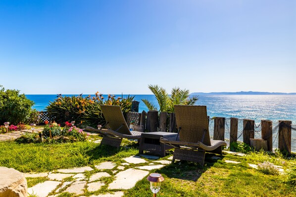 A patio with wicker chairs and a table overlooking a body of water. - Oceanfront-2730 sqft w/SPA, HugeDeck+Garden+VIEWS (San Pedro)