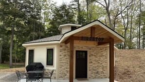 A small, single-story building with a stone facade and a wooden porch.