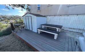 Enjoy a peaceful retreat on the deck with a bench and storage shed.
