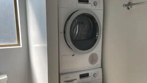 A compact laundry room with two stacked washing machines, a toilet, and a sink. - Large 1BR1BA with ocean view+walking to downtown (Sausalito)