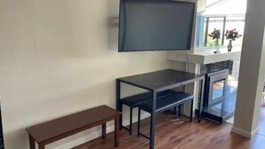 A room with a wooden bench, a black TV mounted on the wall, and a glass cabinet below. - Large 1BR1BA with ocean view+walking to downtown (Sausalito)