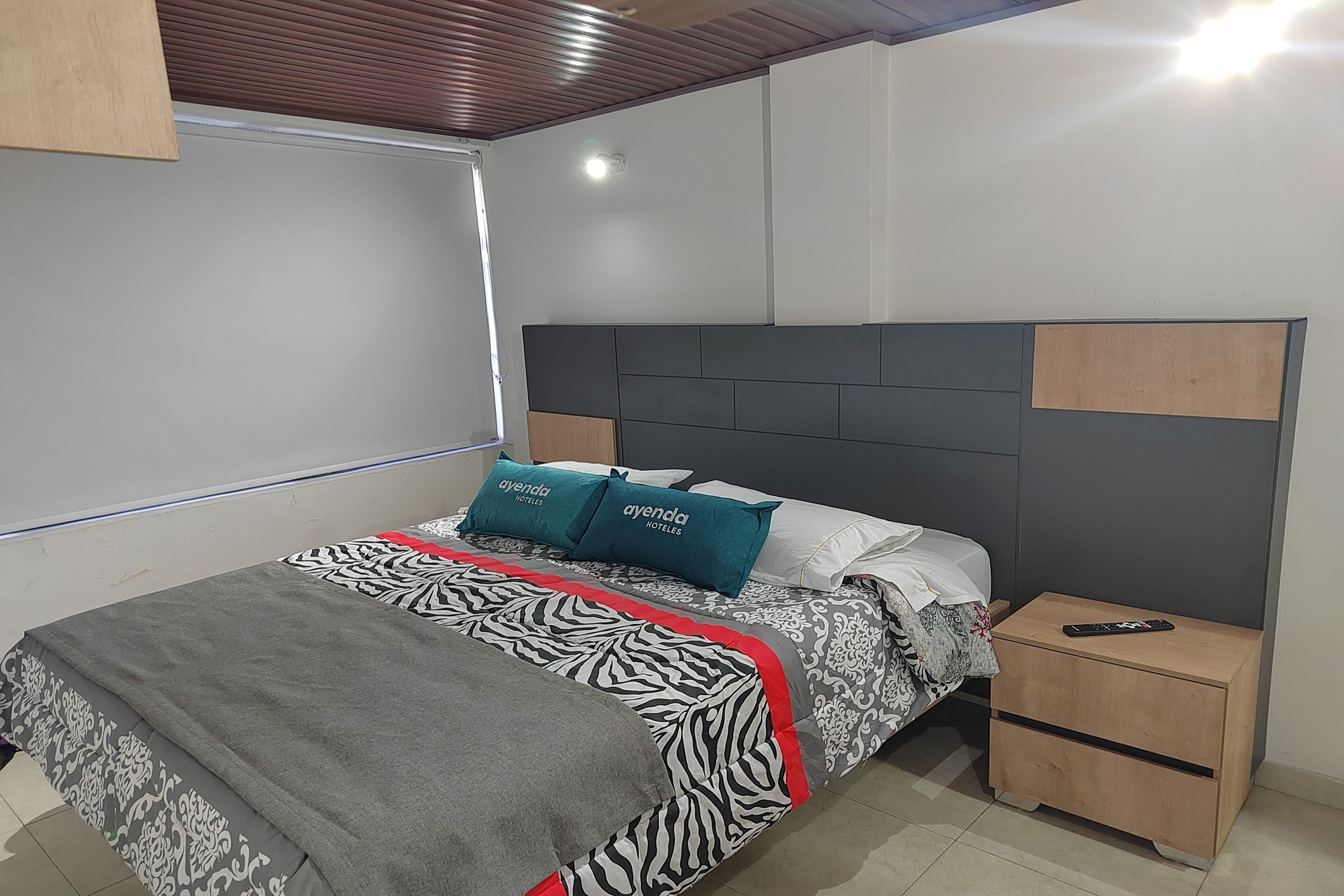 A modern bedroom with a bed, a nightstand, and a headboard.