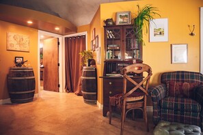 A cozy room with a wooden desk, a plaid sofa, and a chair. There are wooden barrels and a map on the wall. - The Eugene Dome: Wine Country, Nature, Hobbit Home (Eugene)
