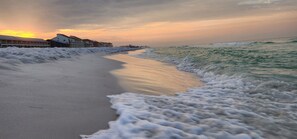 Ein Strand mit einer Reihe von Gebäuden entlang der Küste.