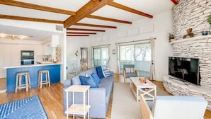 Una sala de estar moderna con un sofá azul, una mesa de centro y una chimenea de piedra.
