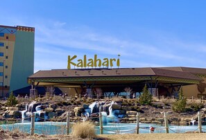 Een gebouw met een bord waarop 'Kalahari' staat en een zwembadgedeelte met een waterval.