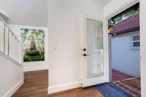 A hallway with a glass door leading to a patio area.