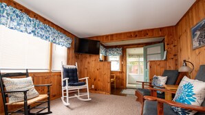 A cozy room with wooden walls, a rocking chair, a sofa, and a television. - Sept 5-12 cancellation, reduced rates! Walk to beach in Wells, 1 dog welcome! (Wells)