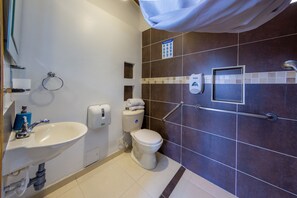 Une salle de bain équipée d’un lavabo, de toilettes et d’une douche.