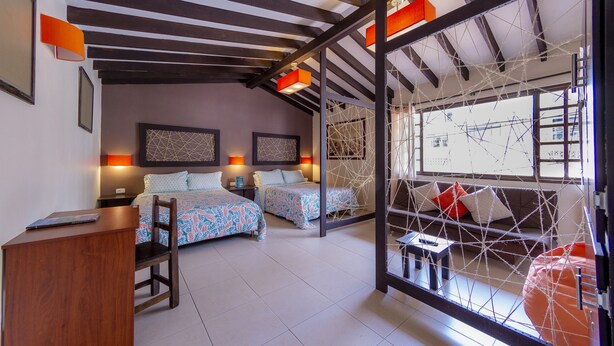 Una habitación de hotel moderna con dos camas, un escritorio y un amplio ventanal.