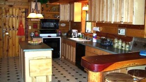 Une cuisine rustique avec des meubles en bois, un îlot central et un four à micro-ondes.