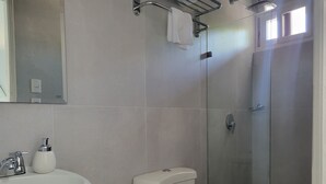 Une salle de bain avec un lavabo, des toilettes et une douche.