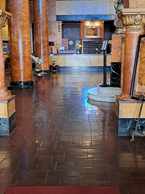 A lobby with marble columns, a reception desk, and a clock on the wall. - The Gadsden Hotel  (Douglas)