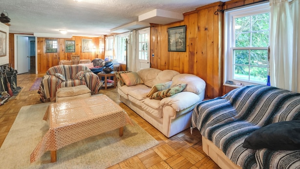 A cozy living room with a beige sofa, striped armchair, and a coffee table. - 3 Mi to NIH! Spacious Bethesda Apt w/ Yard (Bethesda)